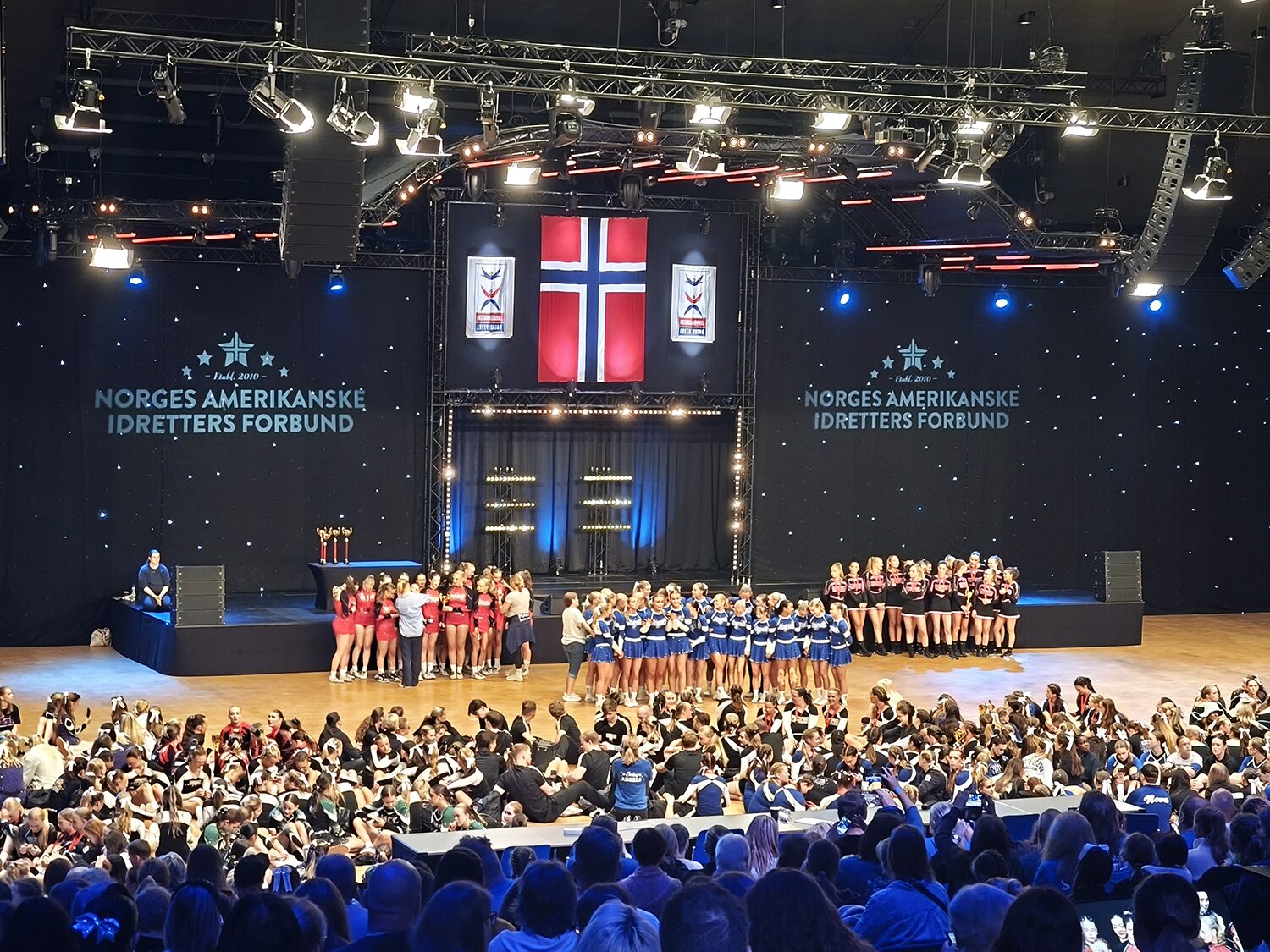 Idrettsarrangement med utøvere og publikum.